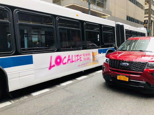 Localize bus side ad in pink spray-paint style